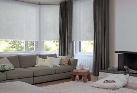 White sheer Roller Blinds combined will full length drapes in living space